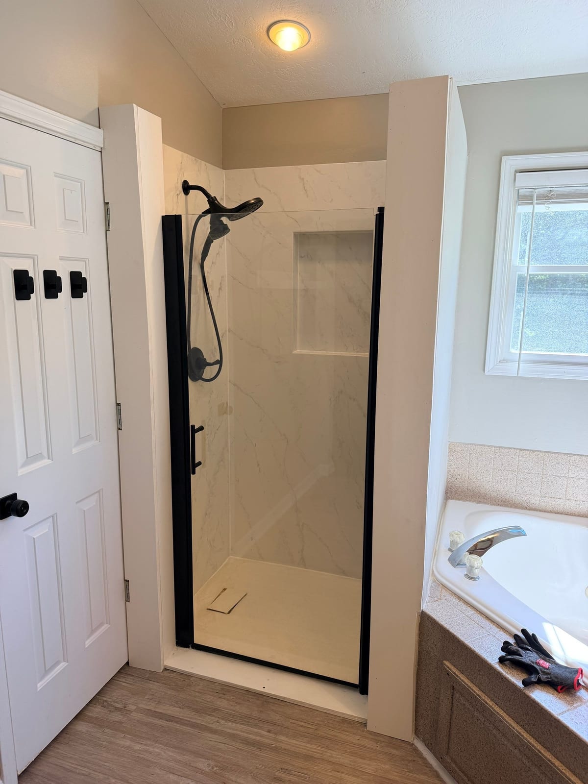 Narrow shower stall beside a garden tub, before replacement by SAS Home Solutions